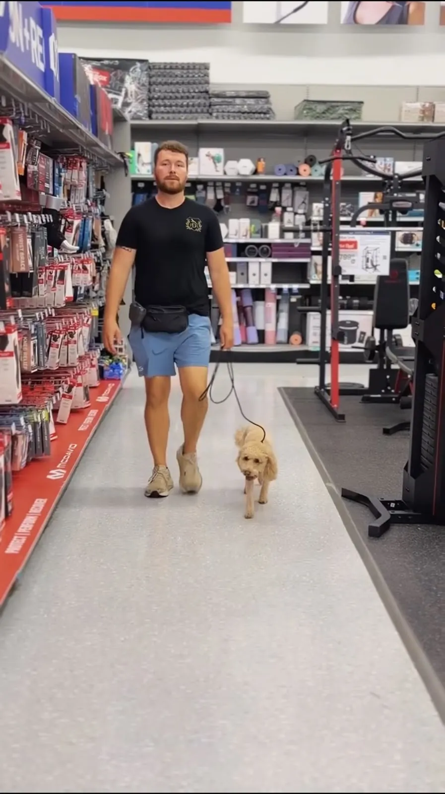 Seth walking a dog through a pet store aisle on a field trip
